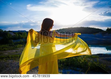 Happy Ukrainian Woman Running In Nature. In A Long Yellow Dress. Symbol Of Freedom Of Ukraine. Woman