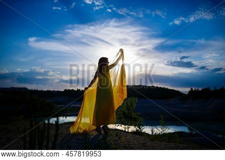 Happy Ukrainian Woman Running In Nature. In A Long Yellow Dress. Symbol Of Freedom Of Ukraine. Woman