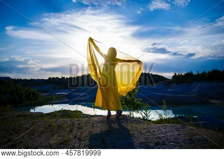 Happy Ukrainian Woman Running In Nature. In A Long Yellow Dress. Symbol Of Freedom Of Ukraine. Woman