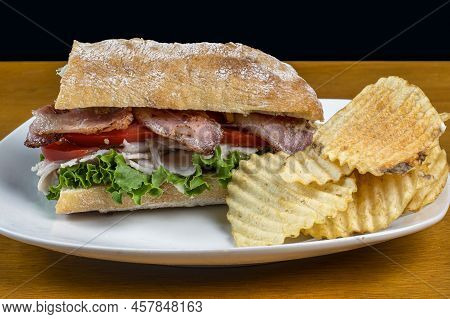 Tukey Meat With A Blt On Ciabatta Bread And A Side Of Potato Chips