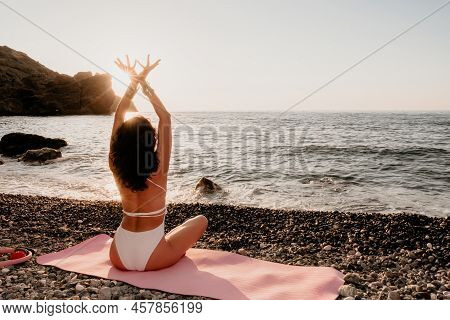 Middle Aged Well Looking Woman In White Swimsuit And Boho Style Braclets Practicing Outdoors On Yoga