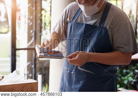 Entrepreneur Woodwork Holding A Tacker To Assemble The Wood Pieces As The Customer Ordered