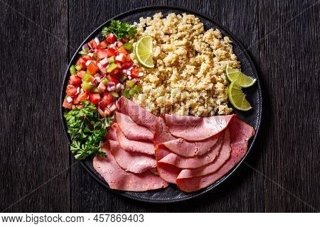 Thinly Sliced Roast Beef Fillet With Quinoa And Tomato Pepper Salsa On Black Plate On Dark Wooden Ta