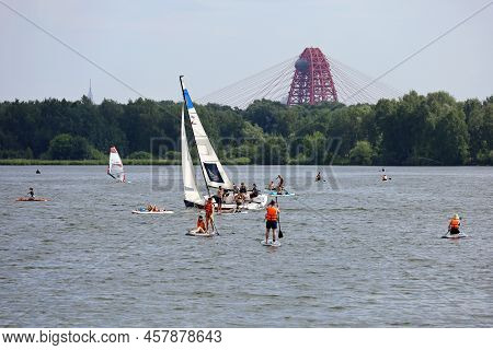 Moscow, Russia - July 2022: Sailing Yacht And People On Paddle Boards On Moscow River In Strogino Di
