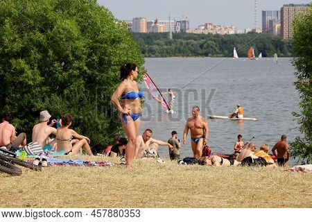 Moscow, Russia - July 2022: People Sunbathing On A Beach On Background Of Moscow River In Strogino, 