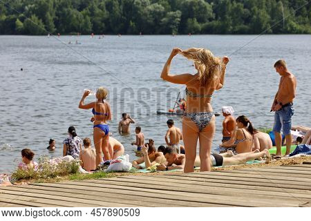 Moscow, Russia - July 2022: People Sunbathing On A Beach On Background Of Moscow River In Strogino, 