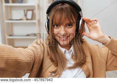 Cute Young Blonde Student Lady Freelancer In Warm Sweater In Headphones Listen Fav Songs Sitting In 