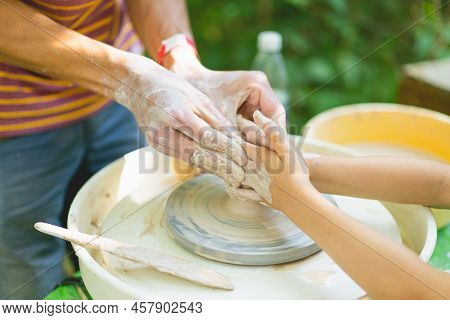 Potter Making A Clay Object On Pottery Wheel In Outdoors. Craftsman Moulding Clay With Hands On Pott