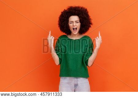 Angry Aggressive Woman With Afro Hairstyle Wearing Green Casual Style Sweater Screaming Angrily, Sho