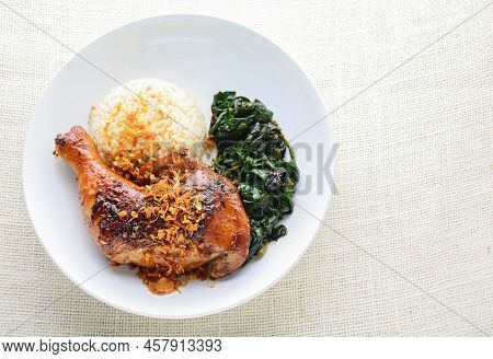 Chicken Drumstick Marinated With Spicy Chilli Sauce And Herbs, Served With Cooked Rice And Spinash.