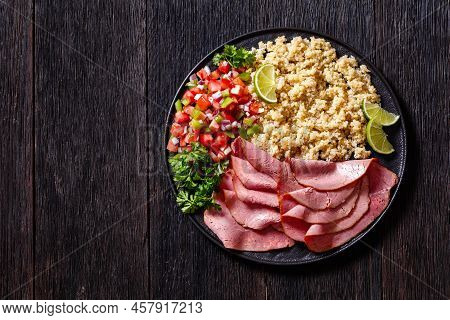 Thinly Sliced Roast Beef Fillet With Quinoa And Tomato Pepper Salsa On Black Plate On Dark Wooden Ta