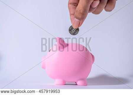 Save Money And Account Banking For Finance Concept, Hand With Piggy Bank And Coin On Blurred Backgro