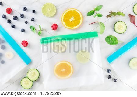 Food Storage Bags With Fruit And Vegetables, Overhead Flat Lay Shot On A White Marble Kitchen Table.