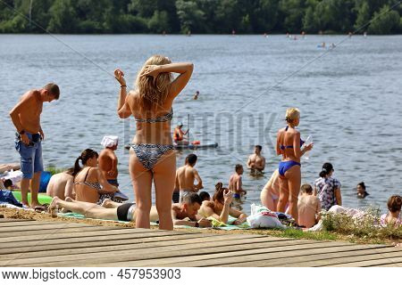 Moscow, Russia - July 2022: People Sunbathing On A Beach On Background Of Moscow River In Strogino, 