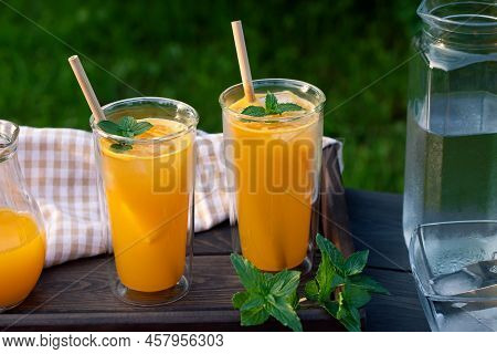 Refreshing Summer Homemade Orange Cocktail In Tall Double Glass Glasses With Mint And Ice, Selective