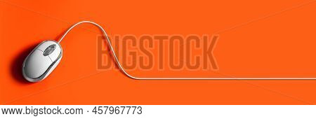 Computer Mouse On An Orange Background. Mouse With Cable. Background For Web Design.