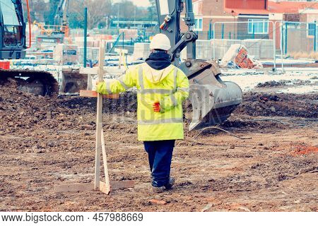 Excavator Digging And Levelling Ground On Construction Site. Digging To The Correct Level With Help 