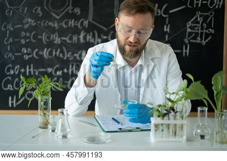 Laboratory Research Scientist Man Conducts Experiments In A Biotechnology Lab With Use Of Dropper An