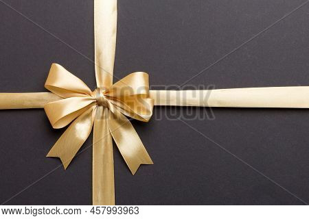 Top View Of Gold Ribbon Rolled And Yellowbow Isolated On Colored Background. Flat Lay With Copy Spac
