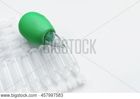 Single Dose Ampoules Of Sterile Isotonic Sea Water Solution And Nasal Aspirator On White Background,