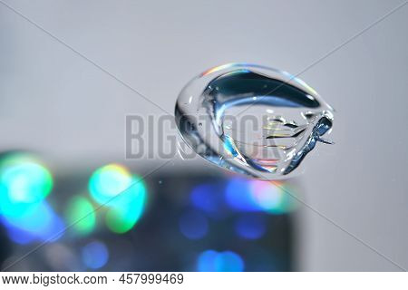 Drop Of Cosmetic Transparent Gel On A Halographic Background. The Texture Of The Serum, Heir Gel Or 