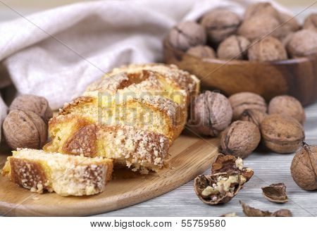 A Delicious Cake And Walnuts In A Wooden Cup