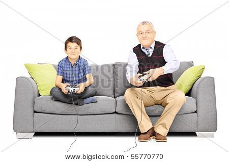 Grandfather with his nephew seated on a sofa playing video games isolated on white background