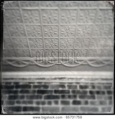 Instagram style image of an old tin ceiling tiles and brick wall