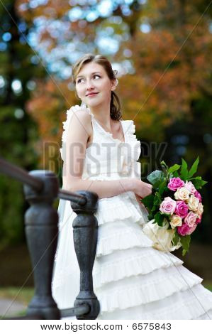 Bruid In witte jurk met bos van bloemen