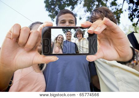 Hand holding smartphone showing low angleshot of three students shoulder to shoulder