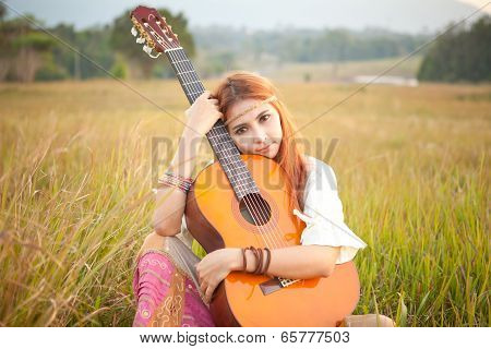 Hippie Girl Playing Guitar On Grass