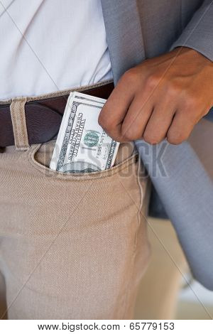 Dodgy businessman pocketing wad of dollars in his office