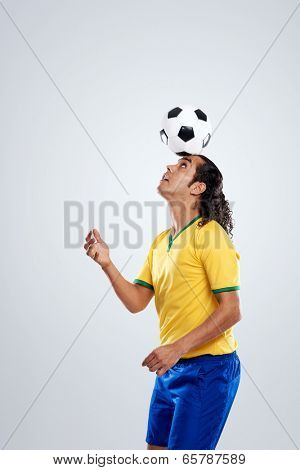 football player ballancing soccer ball on head in display of skill