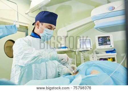 vascular surgeon in uniform perform operation on a patient at cardiac surgery clinic