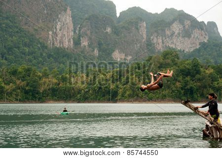 Tourists Fun Jumping Water In Cheow Larn Lake (ratchaprapa Dam),Thailand.