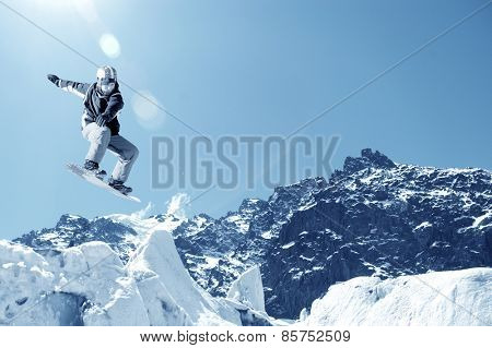 Snowboarder making jump high in clear sky