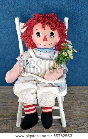 old rag doll with daisy bouquet