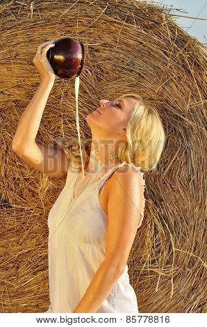 Happy woman drinking milk from cruse or crock