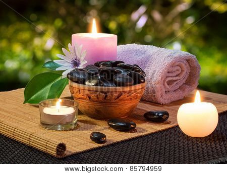 jar of black stones and candles on mat