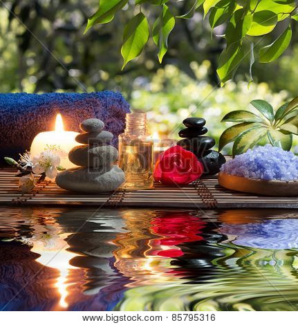 Candles , towels, stones and almond flowers in water