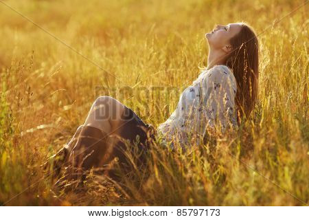 Happy Woman Sitting In The Grass