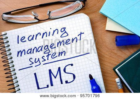 Note with words learning management system LMS on a wooden background.