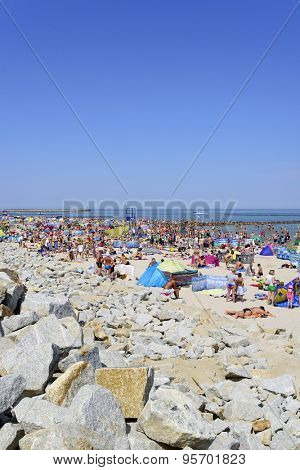 USTKA - JULY 04: Tourists enjoy the sunny weather and relaxing on the Baltic sea beach on 04 July 2015 in Ustka, Poland.
