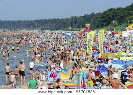 USTKA - JULY 05: Tourists enjoy the sunny weather and relaxing on the Baltic sea beach on 05 July 2015 in Ustka, Poland.