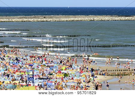 USTKA - JULY 07: Tourists enjoy the sunny weather and relaxing on the Baltic sea beach on 07 July 2015 in Ustka, Poland.