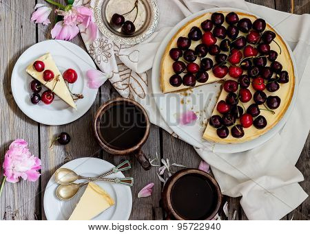 Cheesecake With Cherry, Two Slices On Saucers And Metal Tray  On A Wooden Table. .