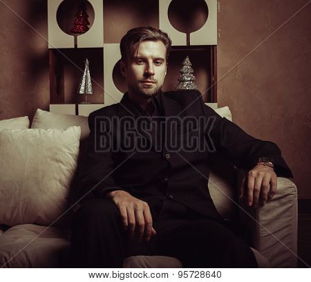 Businessman sitting on an armchair. Fahion man.