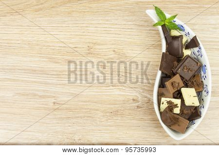 We love chocolate. Chocolate in a porcelain bowl on the table.