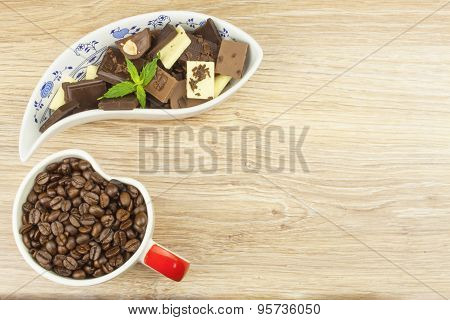 We love coffee and chocolate. Chocolate and coffee on a wooden table.