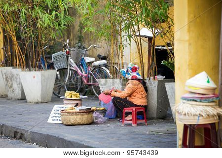 Vietnamese woman selling food on the street of Hoi An